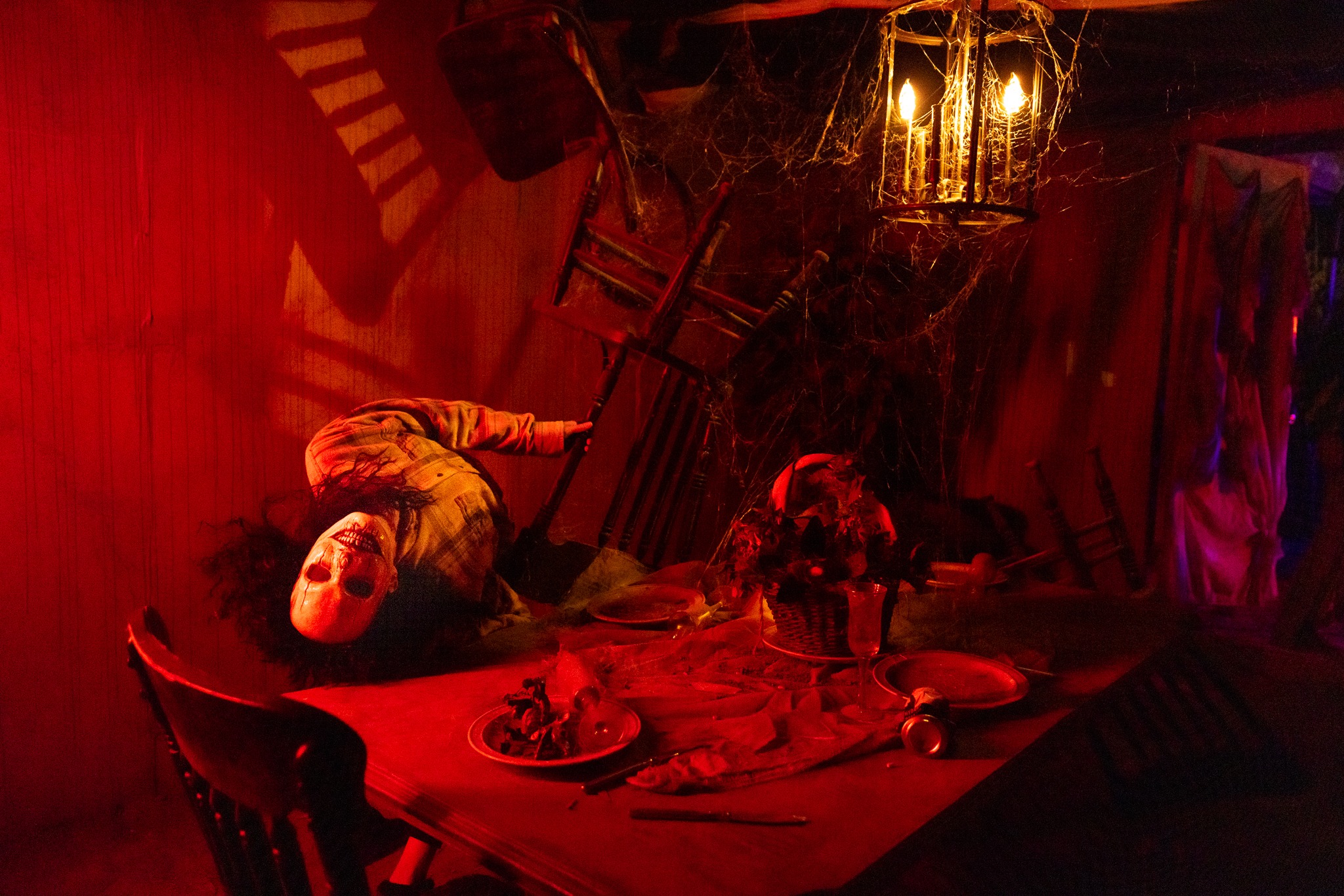 Field of Fright actor inside a red-lit haunted farmhouse scene