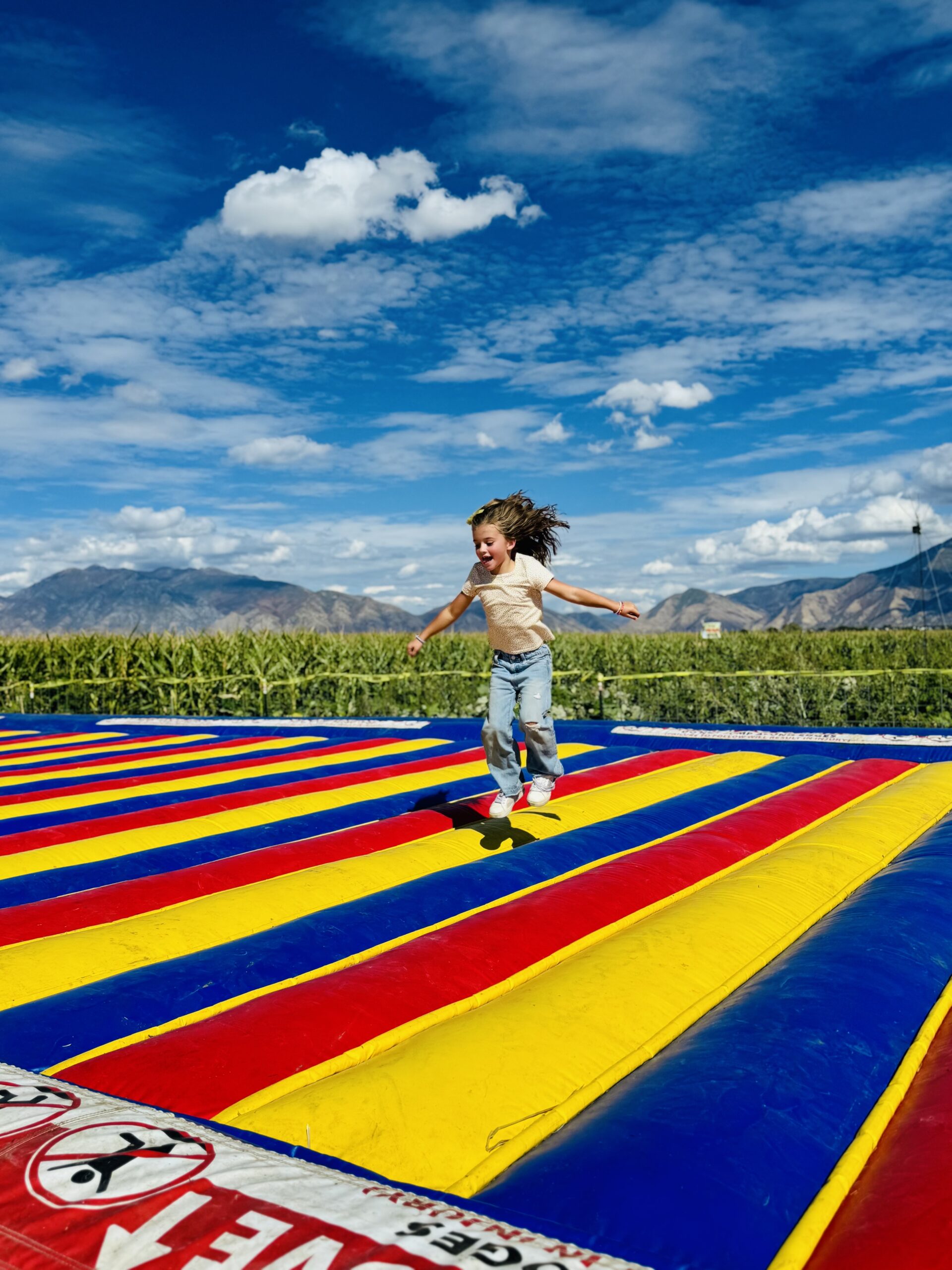 A child jumping on the colorful jump pad at Glen Ray’s Corn Maze